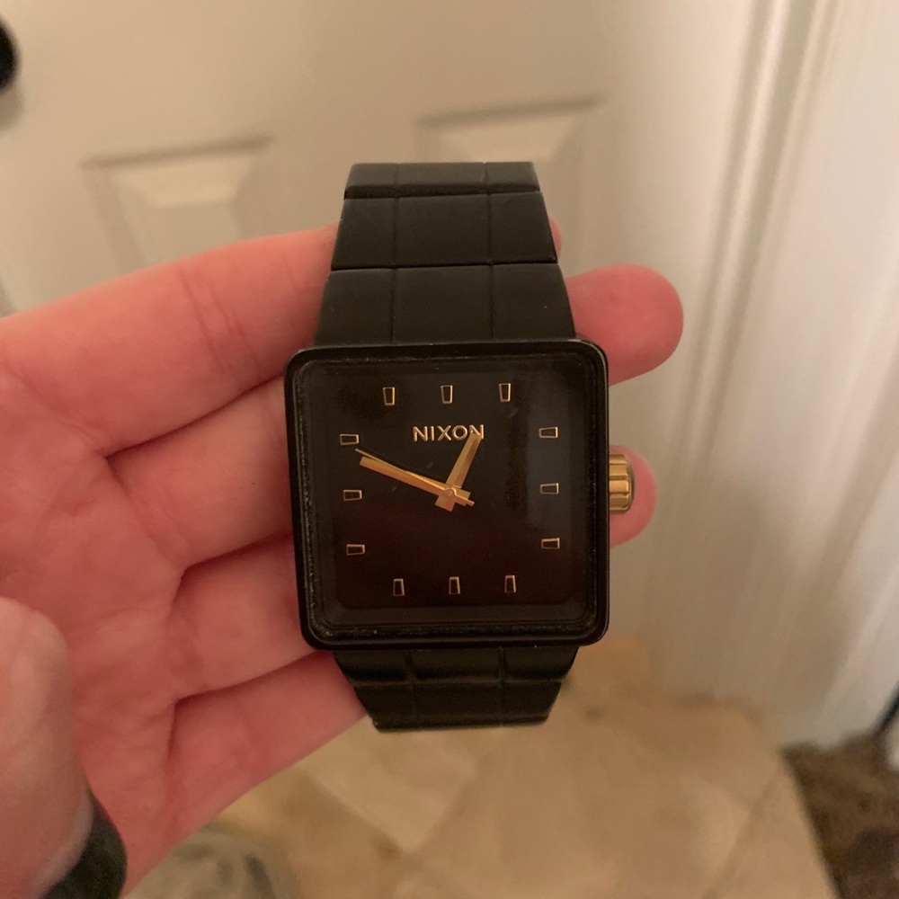 Men’s black and gold Nixon watch